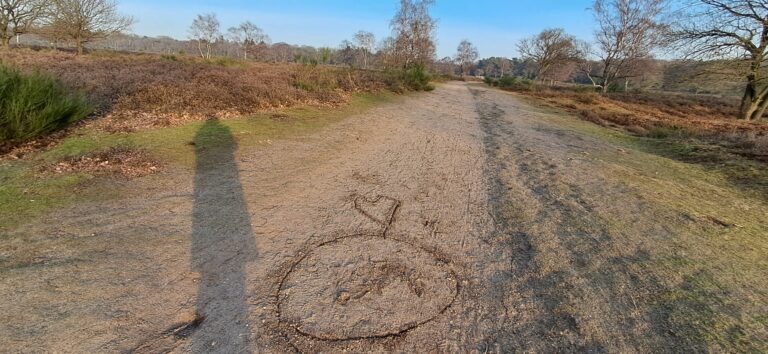 Natuurpad met hartje in het zand, symbool voor jezelf een compliment geven