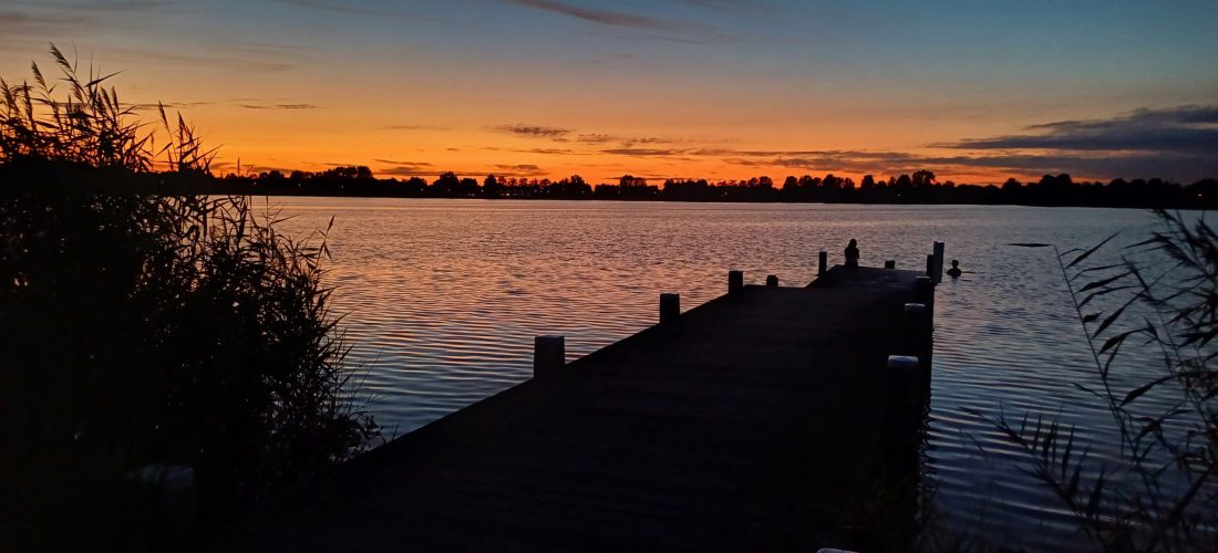 Steiger aan het water bij zonsondergang, een moment van rust, reflectie en terugkijken op het jaar.